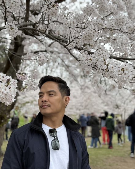 Kiko, founder of Kwaderno & Co., beneath cherry blossoms